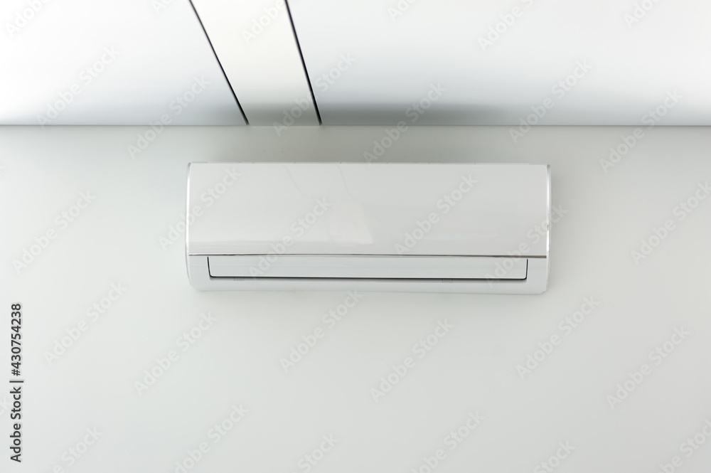 A new air conditioner unit on the white wall A new air conditioner unit on the white wall