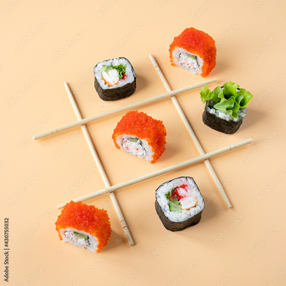 Tic tac toe game with sushi on orange background, creative concept