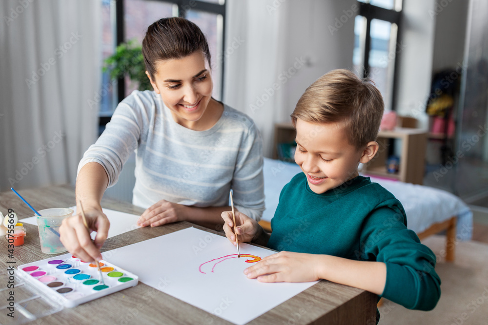 family, leisure and people concept - mother and little son with colors and paper drawing at home family, leisure and people concept - mother and little son with colors and paper drawing at home