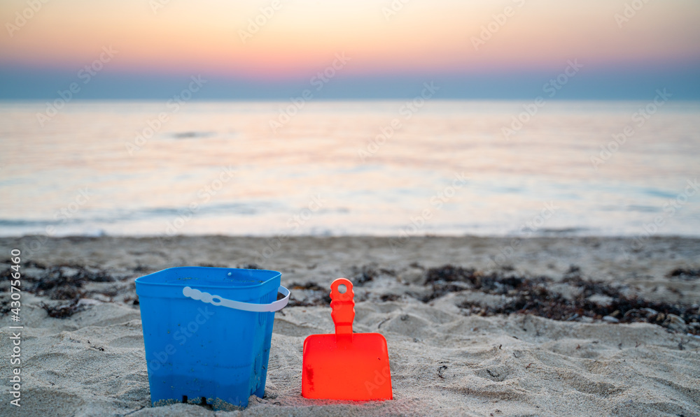 Children's beach toys - buckets, spade and shovel on sand on a sunny day Children's beach toys - buckets, spade and shovel on sand on a sunny day