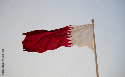 National flag of Qatar flying high. qatar flag. selective focus photo