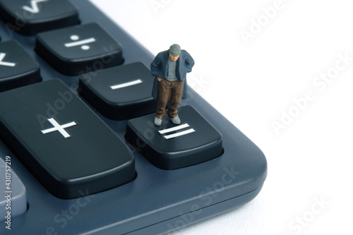 Poor man with no money left standing above calculator. Miniature tiny people toys photography. isolated on white background.