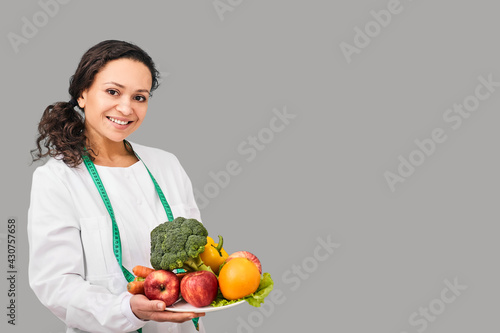 Positive dietitian with fruits and vegetables for healthy eating and diet. Healthy food, dietitian consultation photo