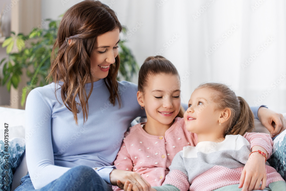 people, family and love concept - happy smiling mother with two daughters at home