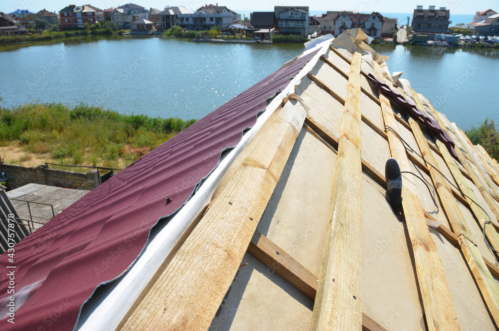 Metal roofing construction: A close-up on an unfinished roof ridge with ... - Low Pitch Metal Roofing Installation Cost Upper Ridge