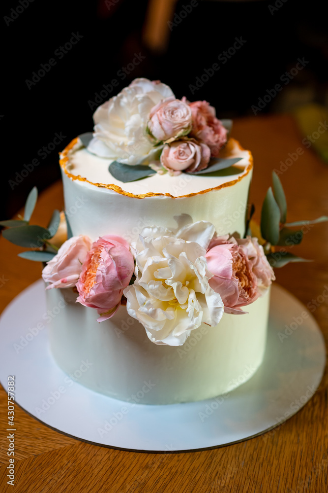 white cake decorated with live flowers. Traditional wedding cake. white cake decorated with live flowers. Traditional wedding cake.