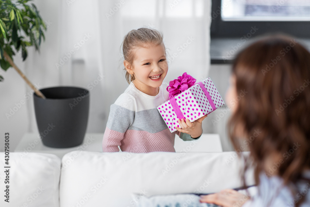people, family and holidays concept - happy little daughter giving present to her mother at home people, family and holidays concept - happy little daughter giving present to her mother at home