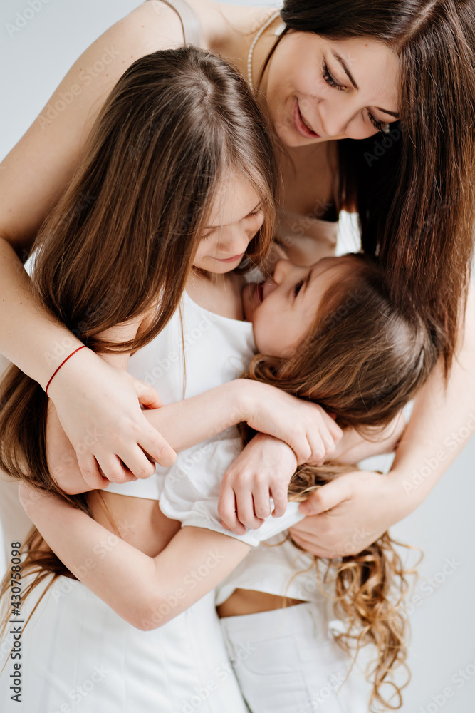 Mom cuddles with her daughters. happy family. Mom cuddles with her daughters. happy family.