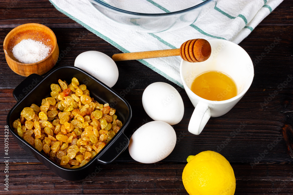 Raisins, chicken eggs, honey and sugar on the kitchen table. Products, ingredients. Raisins, chicken eggs, honey and sugar on the kitchen table. Products, ingredients.