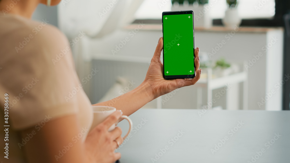 Business woman browsing on internet using mock up green screen chroma key smartphone sitting at office desk. Freelancer swiping online information for social media project using isolated device Business woman browsing on internet using mock up green screen chroma key smartphone sitting at office desk. Freelancer swiping online information for social media project using isolated device