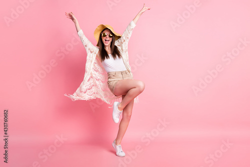 Full length photo of pretty positive girl raise hands knee open mouth isolated on pink color background