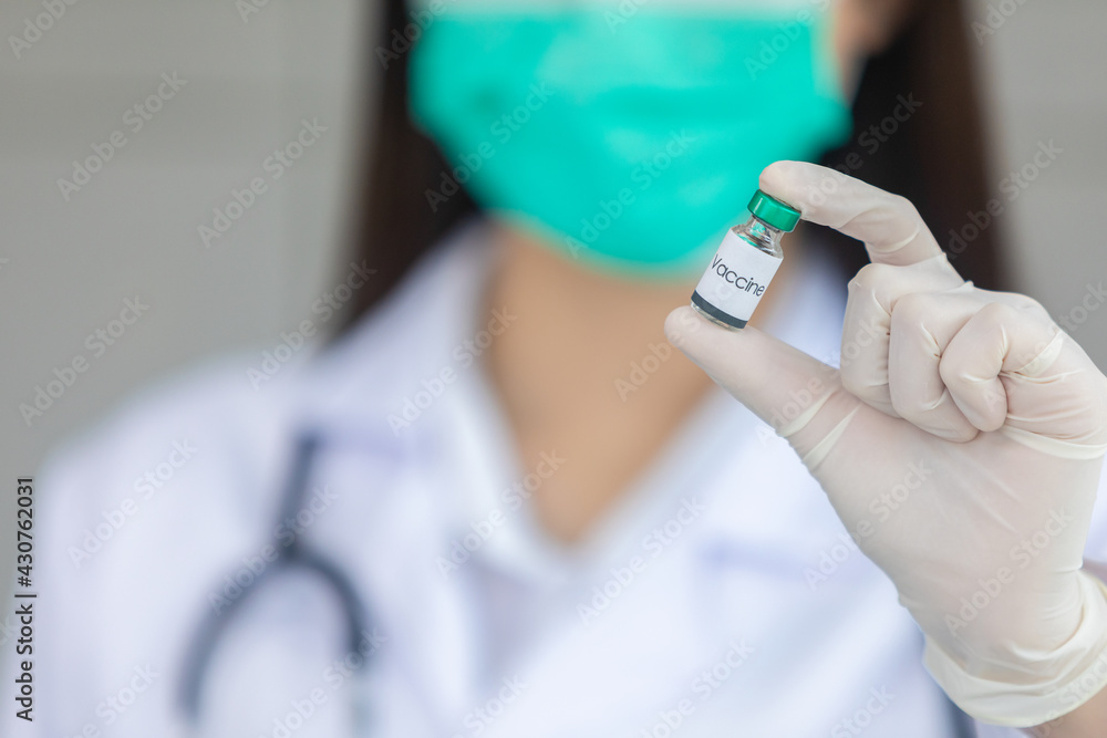 Doctor holding vial with vaccine against closeup Doctor holding vial with vaccine against closeup