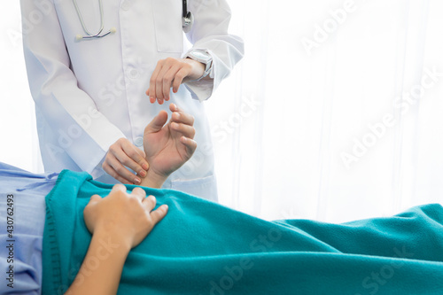 Doctor checking man pressure and pulse in hospital