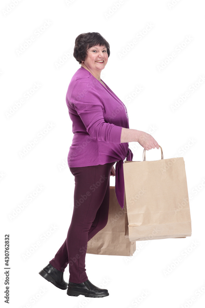 casual elderly woman with shopping bags striding forward. casual elderly woman with shopping bags striding forward.