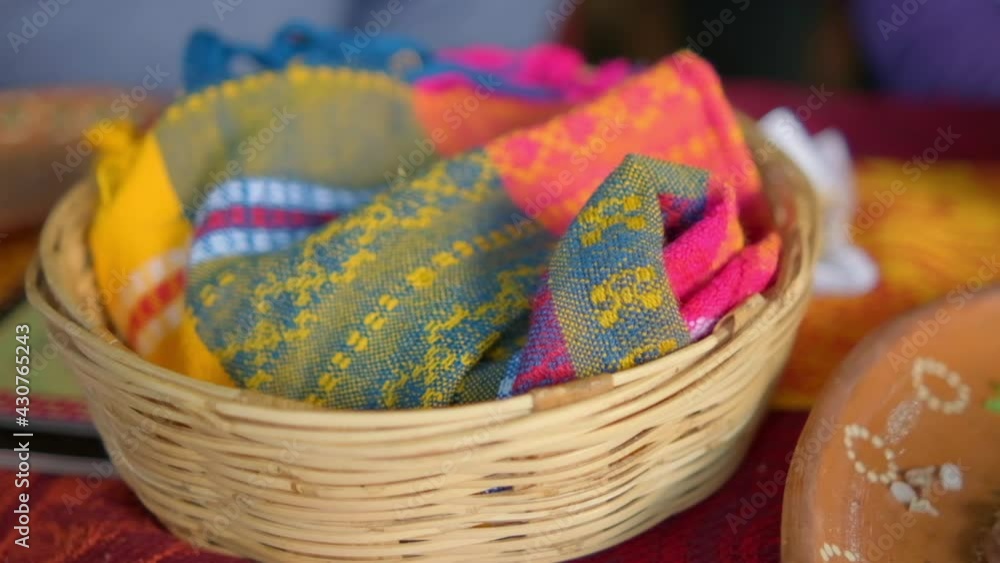 Artisanal tortilla napkin in basket above red and orange tablecloth Artisanal tortilla napkin in basket above red and orange tablecloth