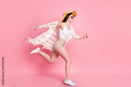 Photo of shiny pretty young woman dressed white cardigan headwear jumping high running fast isolated pink color background