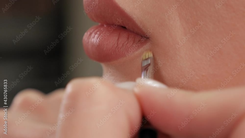Close-up of a cosmetologist painting lips with a pencil before permanent makeup. Close-up of a cosmetologist painting lips with a pencil before permanent makeup.