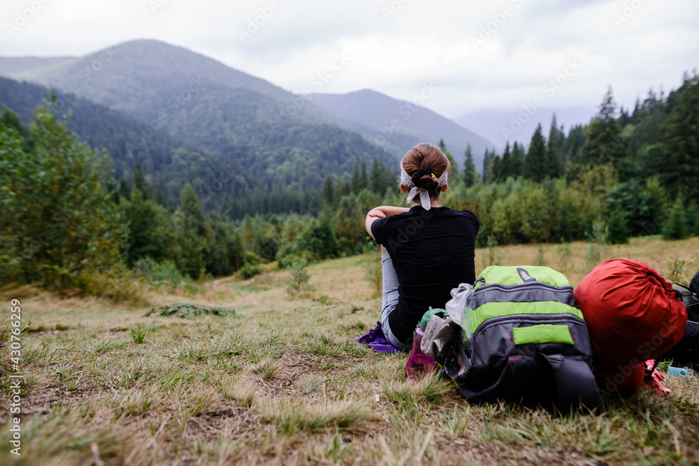 Girl Tourist resting on the Mountain Trail Hike Backpacking Girl Tourist resting on the Mountain Trail Hike Backpacking