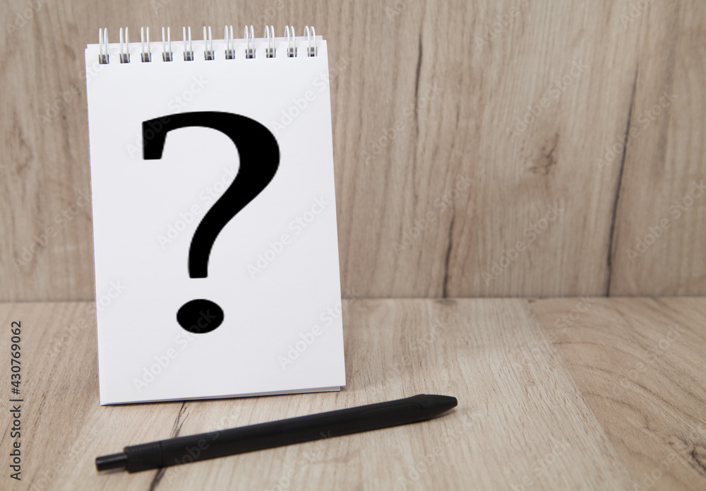 Notebook with question mark and pen on wooden background. Notebook with question mark and pen on wooden background.