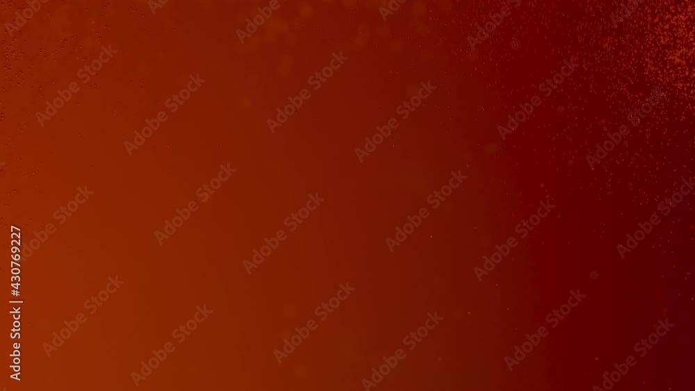 Bubbles in a beer mug. Gas bubbles slowly rise in a glass of cold beer. Close up background texture of an alcoholic beverage pouring orange liquid, bubbling with swirls. Slow motion. Bubbles in a beer mug. Gas bubbles slowly rise in a glass of cold beer. Close up background texture of an alcoholic beverage pouring orange liquid, bubbling with swirls. Slow motion.