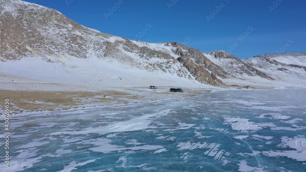A column of 5 SUVs drive through the snow-covered steppe, the footage was shot on a quadrocopter A column of 5 SUVs drive through the snow-covered steppe, the footage was shot on a quadrocopter