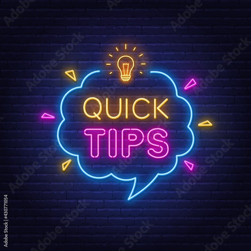 Quick Tips neon sign on brick wall background.