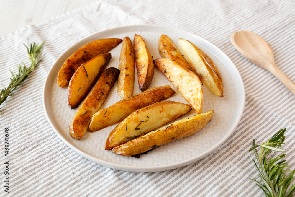 Homemade Rosemary Potato Wedges on a plate, side view.