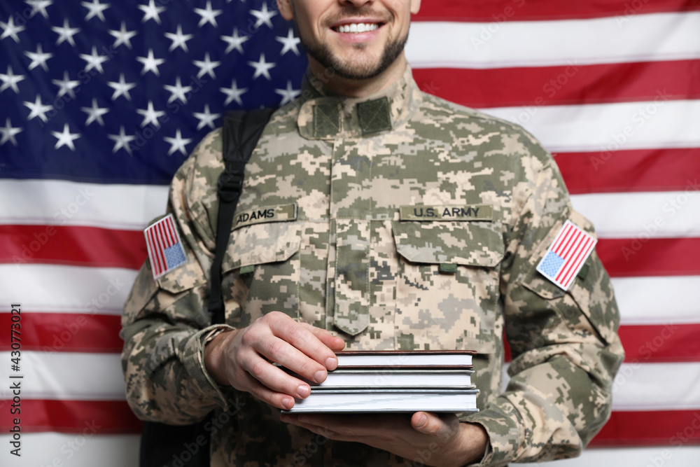 Cadet with backpack and books against American flag, closeup. Military education Cadet with backpack and books against American flag, closeup. Military education