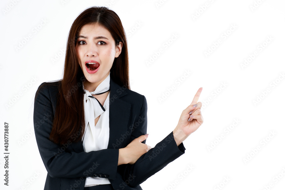 Portrait of young Asian businesswoman in formal suit posing and pointing finger to blank space for present or demonstrate goods or product in advertising gesture, studio shot on white background Portrait of young Asian businesswoman in formal suit posing and pointing finger to blank space for present or demonstrate goods or product in advertising gesture, studio shot on white background