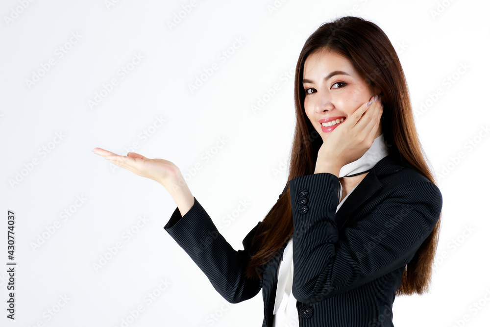 Portrait of young Asian businesswoman in formal suit posing and show hand in blank space for present or demonstrate goods or product in advertising gesture, studio shot on white background