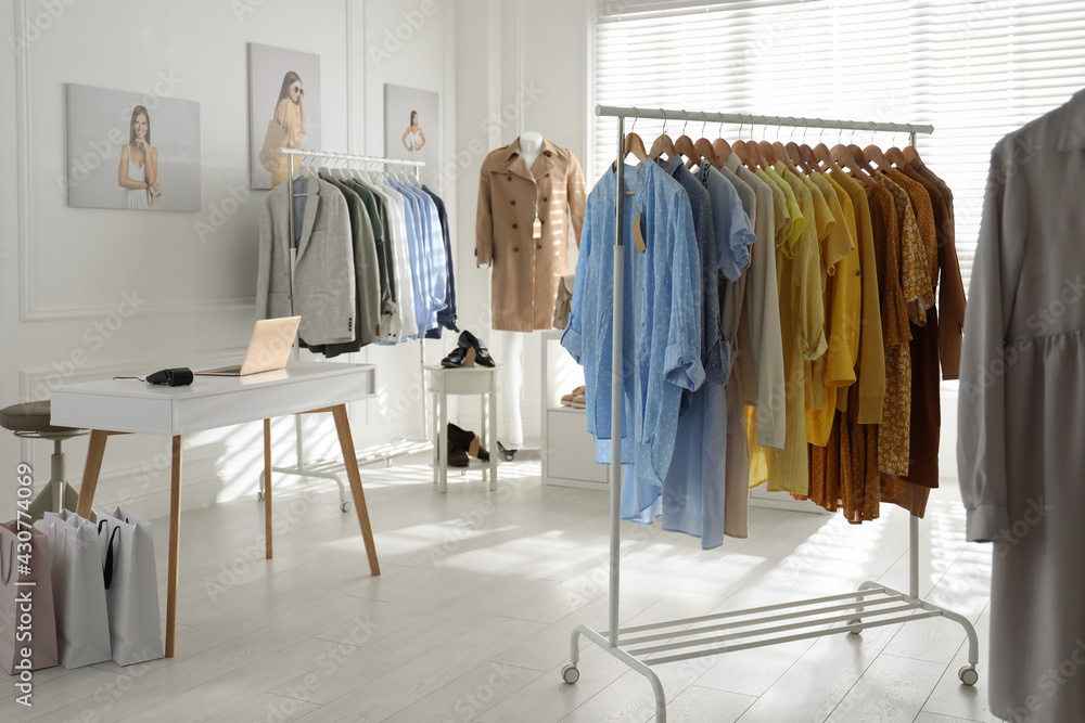 Collection of stylish women's clothes and shoes in modern boutique Collection of stylish women's clothes and shoes in modern boutique