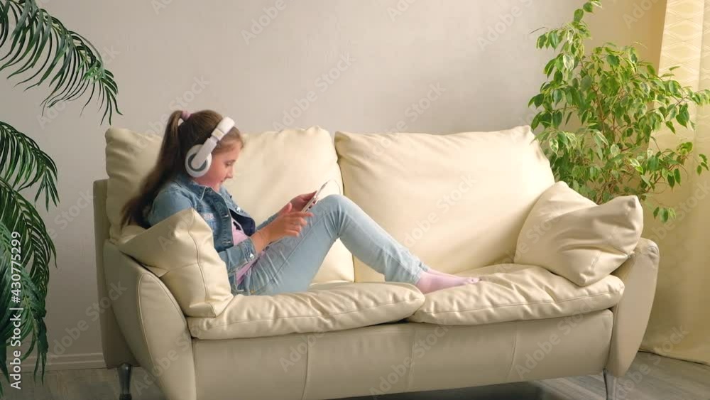 The child in the headphones with the tablet. T The child in the headphones with the tablet. T