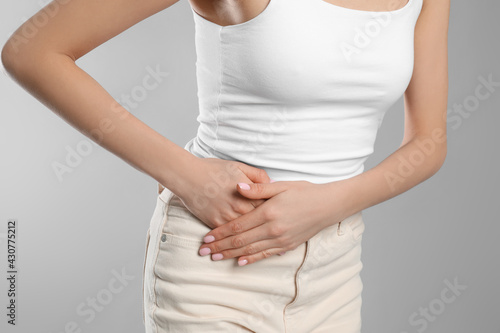 Wallpaper Mural Woman suffering from appendicitis inflammation on grey background, closeup Torontodigital.ca