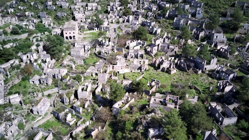 Drone view on world famous Kayakoy ghost town near to Olludeniz, Fethiye. The old ancient city on the beautiful green slope of the hill.
