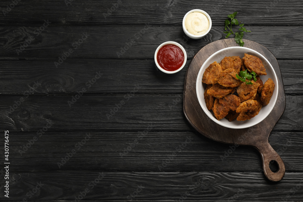 Cooked soy meat in bowl on black wooden table, flat lay. Space for text - obrazy, fototapety, plakaty 