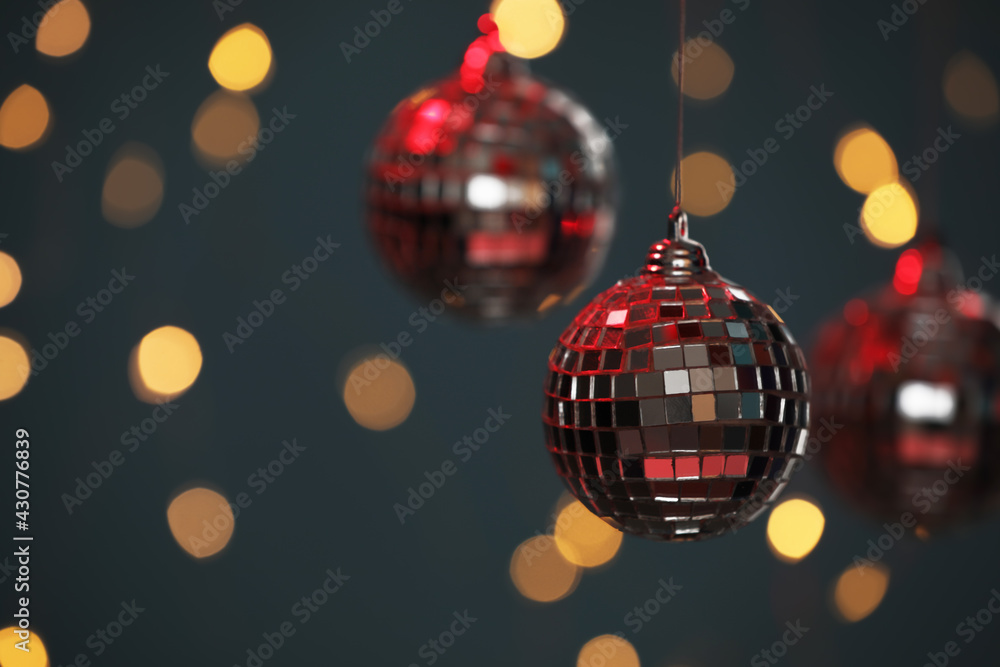 Fototapeta premium Shiny disco balls against blurred lights, space for text