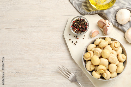 Tasty marinated mushrooms on white wooden table, flat lay. Space for text