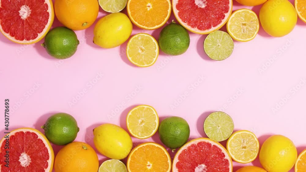 Summer citrus fruits appear on top and bottom of pastel pink background. Stop motion flat lay Summer citrus fruits appear on top and bottom of pastel pink background. Stop motion flat lay