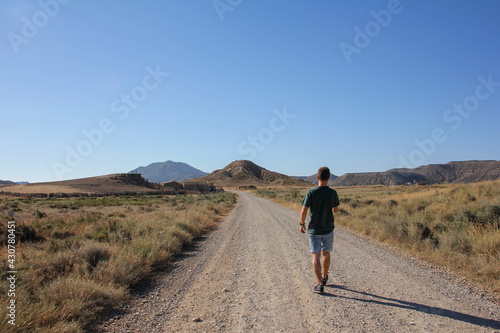 Man walking on a desert-like dirt road in the Bárdenas Reales de Navarra, Spain