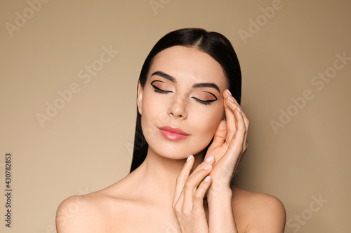 Photos Beautiful woman with black eyeliner on beige background