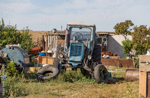 a broken tractor stands in the yard in the village, heavy equipment, special equipment