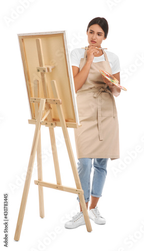 Young woman drawing on easel against white background