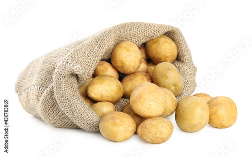 Raw fresh potatoes and sack on white background
