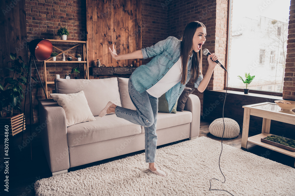 Obraz premium Full length photo of attractive happy charming young woman hold hand mic sing karaoke indoors inside house