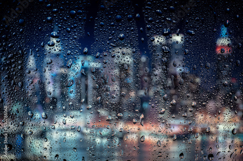 Fototapeta Naklejka Na Ścianę i Meble -  Night city lights through window with rainwater and drops. Background with bokeh.