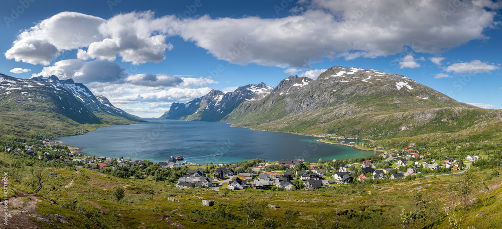 Summer fjord panorama with village at end of it