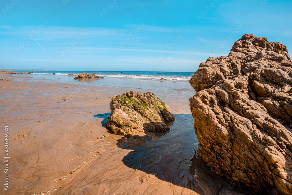 Matador beach and beautiful landscape with rocks and ocean against blue sky, California
