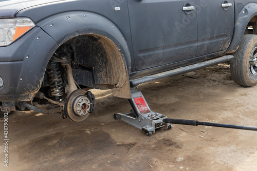 a car stands on a jack without a wheel