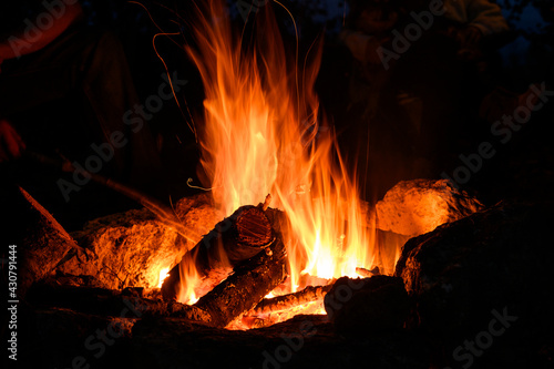 A hot camp fire in nights on a black background. Summer romantic holidays 