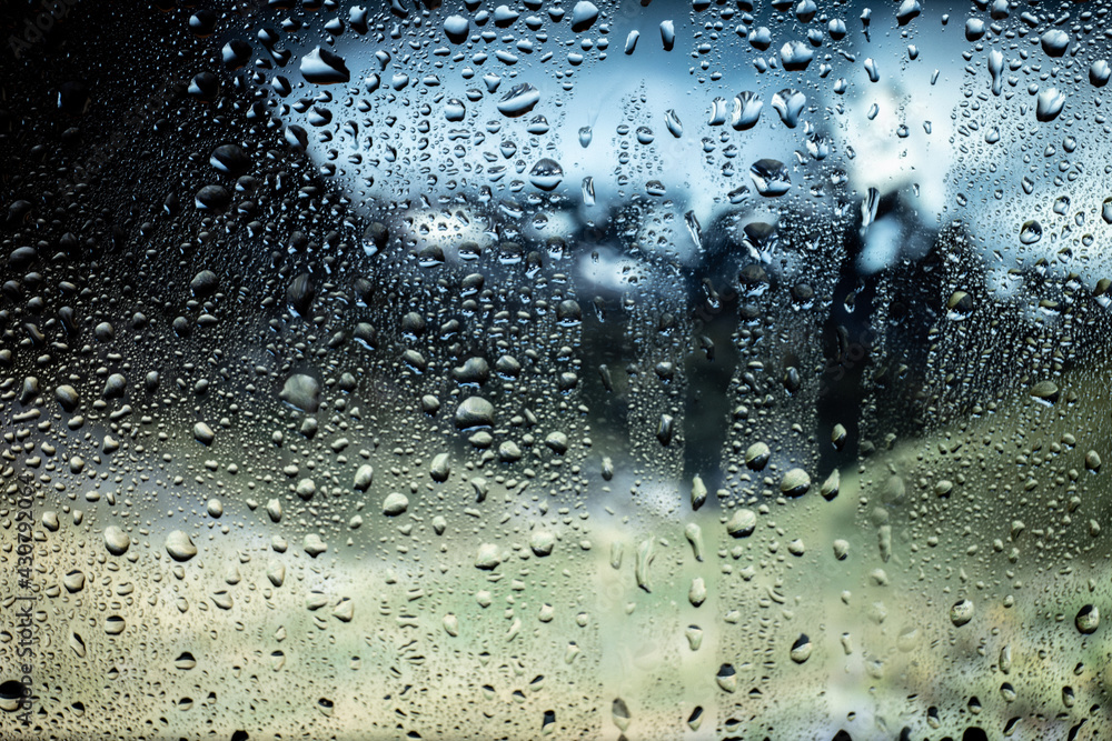 Rain droplets in a window glass, mountains landscape views. Bokeh background. Rain droplets in a window glass, mountains landscape views. Bokeh background.